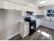 Well-lit kitchen with white cabinets, modern appliances, and ample counter space at 4808 Cedar Ct, Gastonia, NC 28056