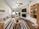 Bright living room featuring a stone fireplace, ceiling fan, and coordinated furniture and decor in neutral tones at 4808 Cedar Ct, Gastonia, NC 28056