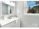 Cozy bathroom features white vanity with brushed nickel hardware and a decorative framed mirror at 5717 Ruth Dr, Charlotte, NC 28215