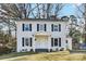 Charming two-story home featuring a white brick facade, black shutters, and a welcoming front porch at 5717 Ruth Dr, Charlotte, NC 28215