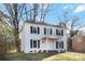 Beautiful two-story home featuring a white brick facade, black shutters, and mature trees in the front yard at 5717 Ruth Dr, Charlotte, NC 28215
