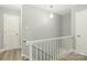 Upstairs hallway with wood-look flooring, white railing, and updated lighting fixture at 5717 Ruth Dr, Charlotte, NC 28215