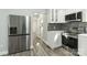 Open Kitchen featuring stainless steel fridge, white cabinets, gray backsplash, and modern floors at 5717 Ruth Dr, Charlotte, NC 28215