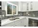 Bright kitchen features stainless steel appliances, mosaic backsplash, white cabinets, and quartz countertops at 5717 Ruth Dr, Charlotte, NC 28215