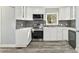 A close-up of the Kitchen with new stainless steel appliances, gray backsplash, and lots of storage at 5717 Ruth Dr, Charlotte, NC 28215