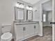 Updated bathroom features double sinks, granite countertops, white cabinets, modern lighting, and a framed mirror at 606 N Elm St, Marshville, NC 28103