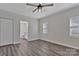 Bright bedroom featuring gray flooring, a ceiling fan, closet and bathroom, with natural light from a window at 606 N Elm St, Marshville, NC 28103