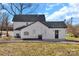 Rear exterior view of the home, featuring a small patio, updated siding, and a spacious lawn at 606 N Elm St, Marshville, NC 28103