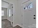 Bright foyer features a front door with glass panels, light gray walls, and gray wood-look floors at 606 N Elm St, Marshville, NC 28103