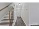 Bright hallway with wood-look floors and a staircase with wood and black metal railings at 606 N Elm St, Marshville, NC 28103