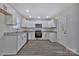 Kitchen with white cabinetry, granite countertops, stainless steel appliances, and wood-look flooring at 606 N Elm St, Marshville, NC 28103