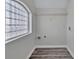 Bright laundry room featuring modern gray flooring and a unique glass block window at 606 N Elm St, Marshville, NC 28103