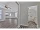 Bright, open-concept living room with ceiling fan and new gray flooring connects to a modern kitchen and bathroom at 606 N Elm St, Marshville, NC 28103