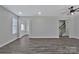 Bright living room with gray flooring leads to a bathroom, laundry room, and staircase to the second floor at 606 N Elm St, Marshville, NC 28103