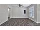 Living room with a ceiling fan, window, light gray walls, and wood-look flooring at 606 N Elm St, Marshville, NC 28103