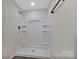 Clean, modern shower stall with built-in shelving, perfect for a minimalist and organized bathroom at 606 N Elm St, Marshville, NC 28103