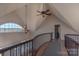 The upper hallway boasts an ornate chandelier, curved railing, and beautiful window view at 627 Birdie Ln # 21/22, Norwood, NC 28128