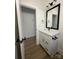 Bathroom featuring a black framed mirror over a white vanity with quartz countertops and wood-look floors at 803 Fargo Dr, Concord, NC 28027
