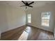 Bright bedroom with two windows, wood-look flooring, ceiling fan, and neutral walls at 803 Fargo Dr, Concord, NC 28027