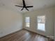 Bright bedroom with two windows, wood-look flooring, and a ceiling fan at 803 Fargo Dr, Concord, NC 28027
