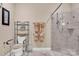 Bathroom featuring accessible toilet, towel racks, and glass shower with gray and white tile at 8439 Sonata Ct, Denver, NC 28037