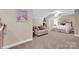Spacious carpeted bedroom featuring neutral walls, a ceiling fan, accent chair, and a comfortable-looking bed at 8439 Sonata Ct, Denver, NC 28037