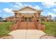 Inviting covered patio with brick columns, steps, and manicured landscaping, ideal for outdoor relaxation at 8439 Sonata Ct, Denver, NC 28037