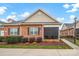 A well-manicured brick home featuring a screened porch, American flag, and tasteful landscaping at 8439 Sonata Ct, Denver, NC 28037