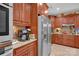 Bright kitchen with stainless steel refrigerator, granite countertops, wood cabinets, and tile floors at 8439 Sonata Ct, Denver, NC 28037