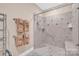 Elegant shower with gray and white tile and glass door featuring towel racks and assist bars at 8439 Sonata Ct, Denver, NC 28037