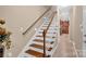 Beautiful staircase leading to the second floor with hardwood steps, white risers, and wooden handrail at 8439 Sonata Ct, Denver, NC 28037