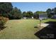 Large, open backyard with a partial wood fence, satellite dish and grassy area at 8915 Touchstone Ln, Charlotte, NC 28227