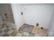 Bathroom featuring a tub with shower, damaged flooring and a closet area with wire shelving at 8915 Touchstone Ln, Charlotte, NC 28227
