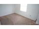 Standard-sized bedroom with old carpet, white walls, and a single window at 8915 Touchstone Ln, Charlotte, NC 28227
