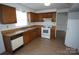 Functional kitchen with wooden cabinets, white appliances, and wood-look flooring at 8915 Touchstone Ln, Charlotte, NC 28227