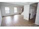 Open-concept living room with plenty of natural light and wood-look floors at 8915 Touchstone Ln, Charlotte, NC 28227