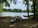 Scenic lake view featuring kayaks on the shore and lush trees, perfect for outdoor enthusiasts at 110 Hazelton Loop, Mooresville, NC 28117