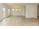 Bright living room features wood-look flooring, three windows, and modern light fixtures at 1101 Red River Dr, Salisbury, NC 28144