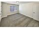 Comfortable bedroom with neutral carpet, one window, and a door with a black handle at 11123 River Oaks Nw Dr, Concord, NC 28027