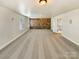 Large bonus room with a brick accent wall, plush carpet, and plenty of natural light at 11123 River Oaks Nw Dr, Concord, NC 28027
