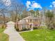A beautiful two-story brick home featuring a lush lawn, attached garage, and classic architectural details against a bright sky at 1116 Berry Ridge Rd, Charlotte, NC 28270