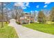 Traditional brick home features an attached garage and long driveway, enhanced by lush landscaping at 1116 Berry Ridge Rd, Charlotte, NC 28270