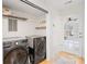 Functional laundry room with side-by-side washer and dryer and convenient shelving at 1116 Berry Ridge Rd, Charlotte, NC 28270
