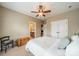 Neutral bedroom with window and blinds, ceiling fan, a chair, and chest. Adjoining bathroom entrance at 1122 Saratoga Blvd, Indian Trail, NC 28079