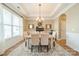 Formal dining room with hardwood floors, a modern chandelier, and views of the landscaped backyard at 1122 Saratoga Blvd, Indian Trail, NC 28079