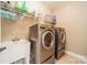 Spacious laundry room with utility sink, wire racks, and modern silver washer and dryer at 1122 Saratoga Blvd, Indian Trail, NC 28079