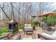 Brick patio with outdoor seating, fireplace, and wooded backdrop at 1122 Saratoga Blvd, Indian Trail, NC 28079