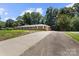 Long, paved driveway leading to a well-kept brick home with mature trees and landscaping at 1210 Brookwood Dr, Shelby, NC 28150