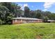 Charming brick ranch home with blue shutters, a green front door, and mature trees in a tranquil setting at 1210 Brookwood Dr, Shelby, NC 28150