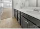 Elegant bathroom with a double vanity, dark cabinets, white countertops, and modern fixtures at 12326 Cranberry Glades Dr, Cornelius, NC 28031